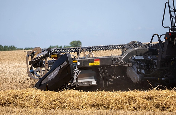 Thumbnail for Side profile of MacDon draper header cutting through golden wheat, delivering clean and uniform crop flow to the combine.