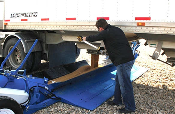 Farmer unloading grain from a semi trailer onto a Brandt GrainDeck, optimizing harvest efficiency.