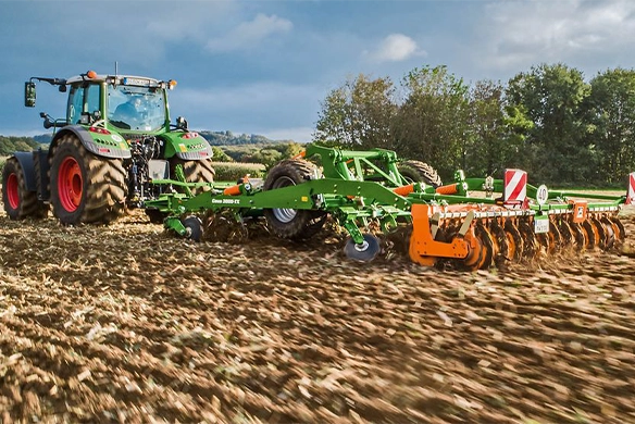 Fendt tractor working in tandem with the Amazone Ceus 6000-2TX cultivator for deep soil loosening and intensive stubble mixing.