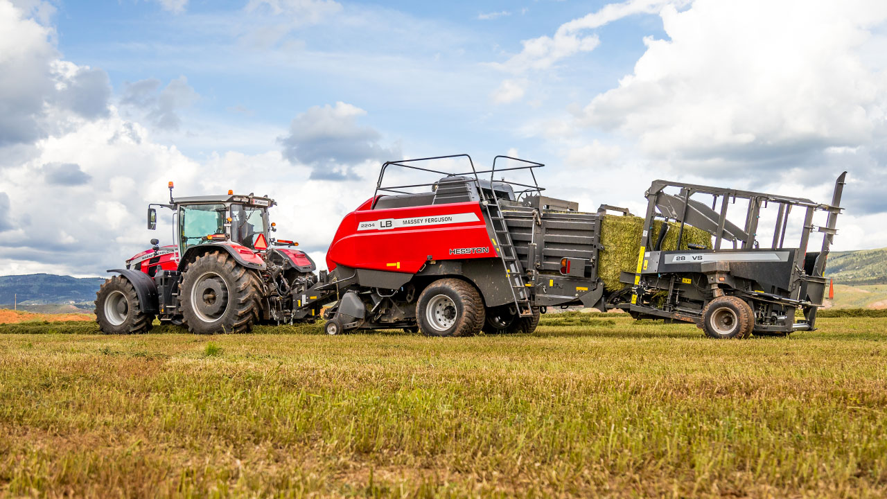 Thumbnail for Hesston by Massey Ferguson LB2200 Series baler in-field with Massey Ferguson tractor and hay stacker, producing square bales.