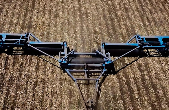 Aerial view of Brandt land roller leveling a harvested field, enhancing seed-to-soil contact.
