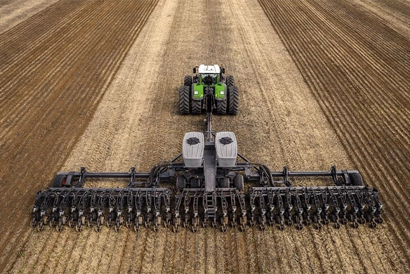 Fendt tractor pulling Fendt Momentum planter across wide field for high-efficiency precision row crop planting.