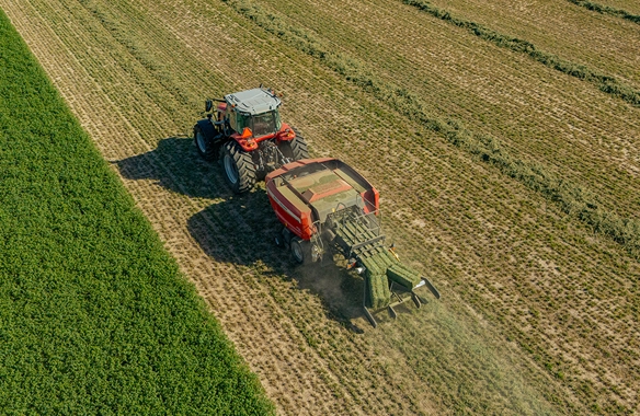 Aerial view of Massey Ferguson tractor operating a Hesston 1436 Series large square baler in a field, showcasing precision hay collection and efficient baling performance.
