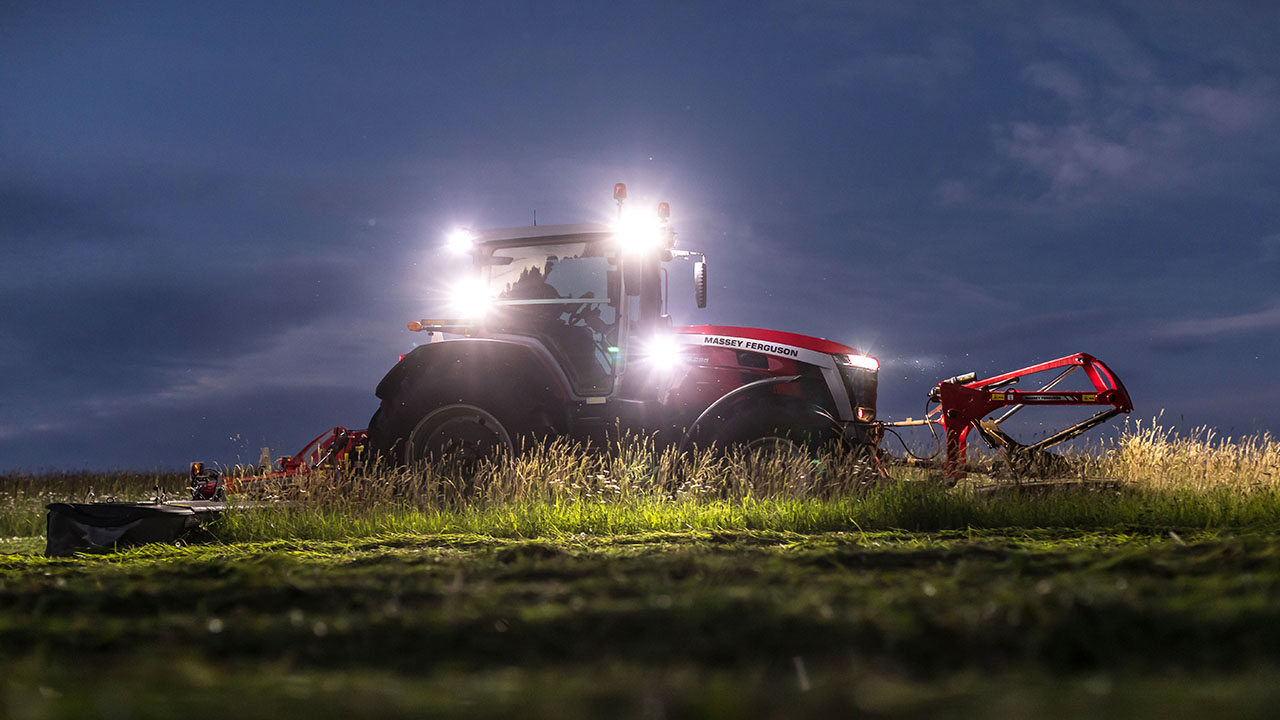 Massey Ferguson tractor with MF DM Series Triple Mower cutting grass at night, delivering high-output mowing with LED work lights.