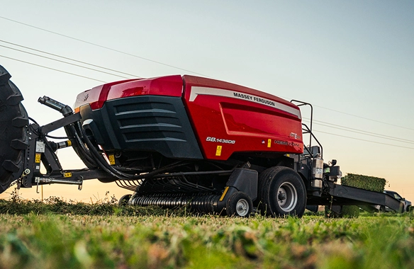 Close-up side view of Hesston by Massey Ferguson 1436 Series baler ejecting a compacted square bale, highlighting durable construction and dense bale formation.