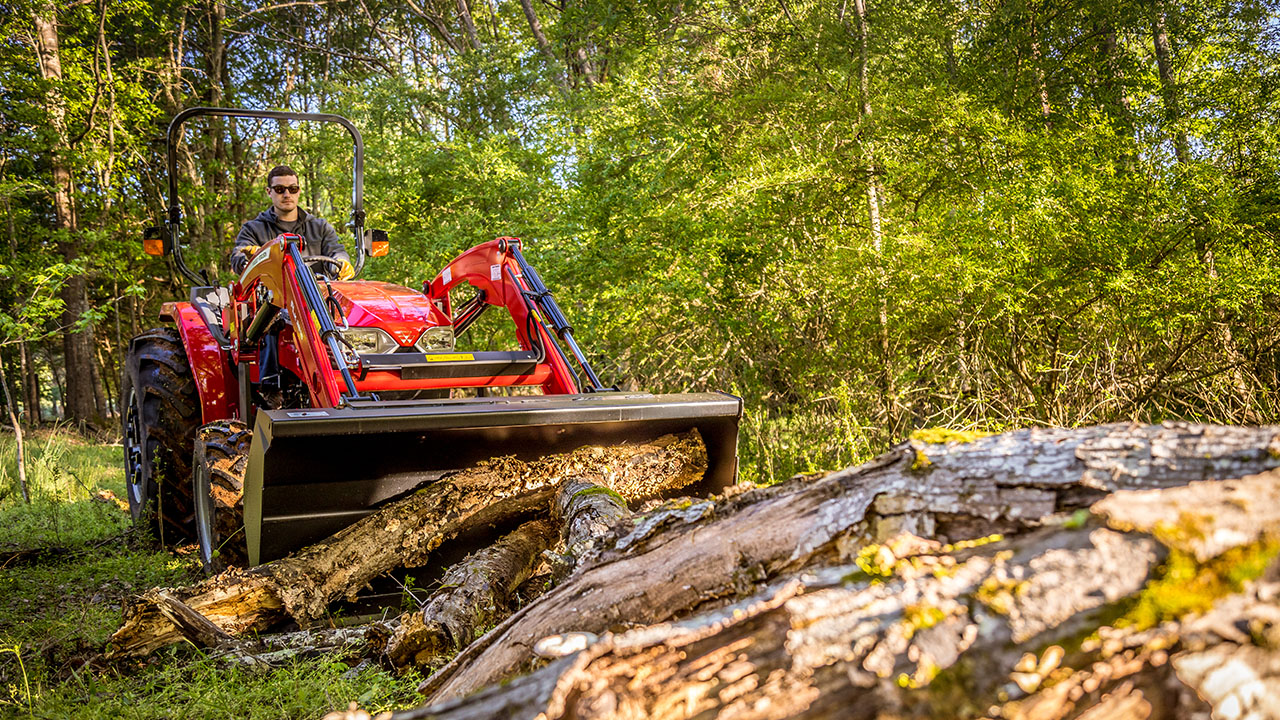 Operator driving a Massey Ferguson 2800E Series compact tractor, ideal for small-scale agriculture tasks.