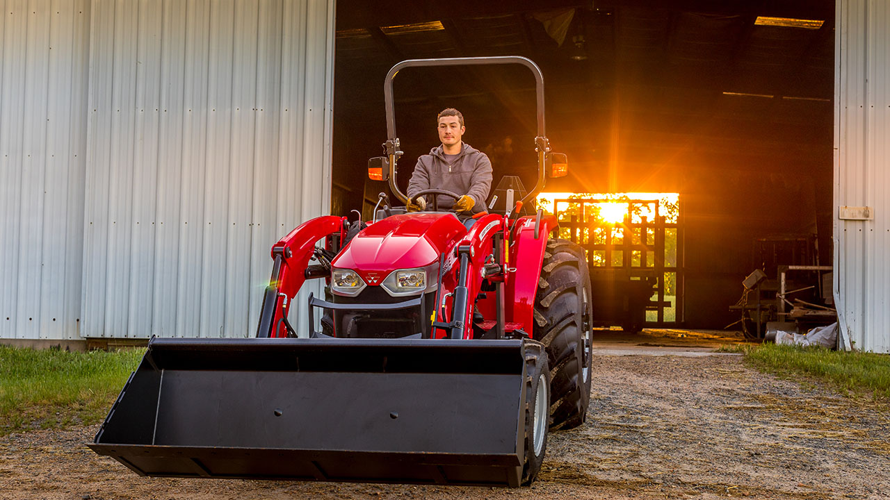 Operator driving a Massey Ferguson 2800E Series compact tractor, ideal for small-scale agriculture tasks.