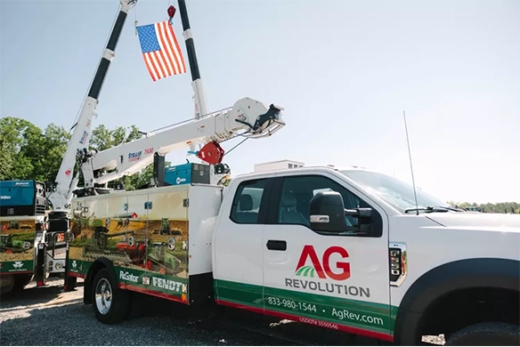 AgRevolution mobile service vehicle with cranes extended displaying the American flag.