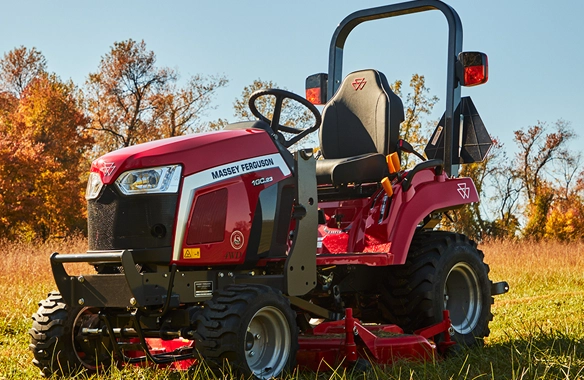Massey Ferguson 1GC Series sub-compact tractor parked on grass in early autum, showcasing its compact design and available mid-mount mower deck.
