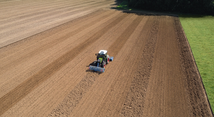 Fendt 200 Vario tractor working a wide, freshly tilled field with precision planter in early season conditions.