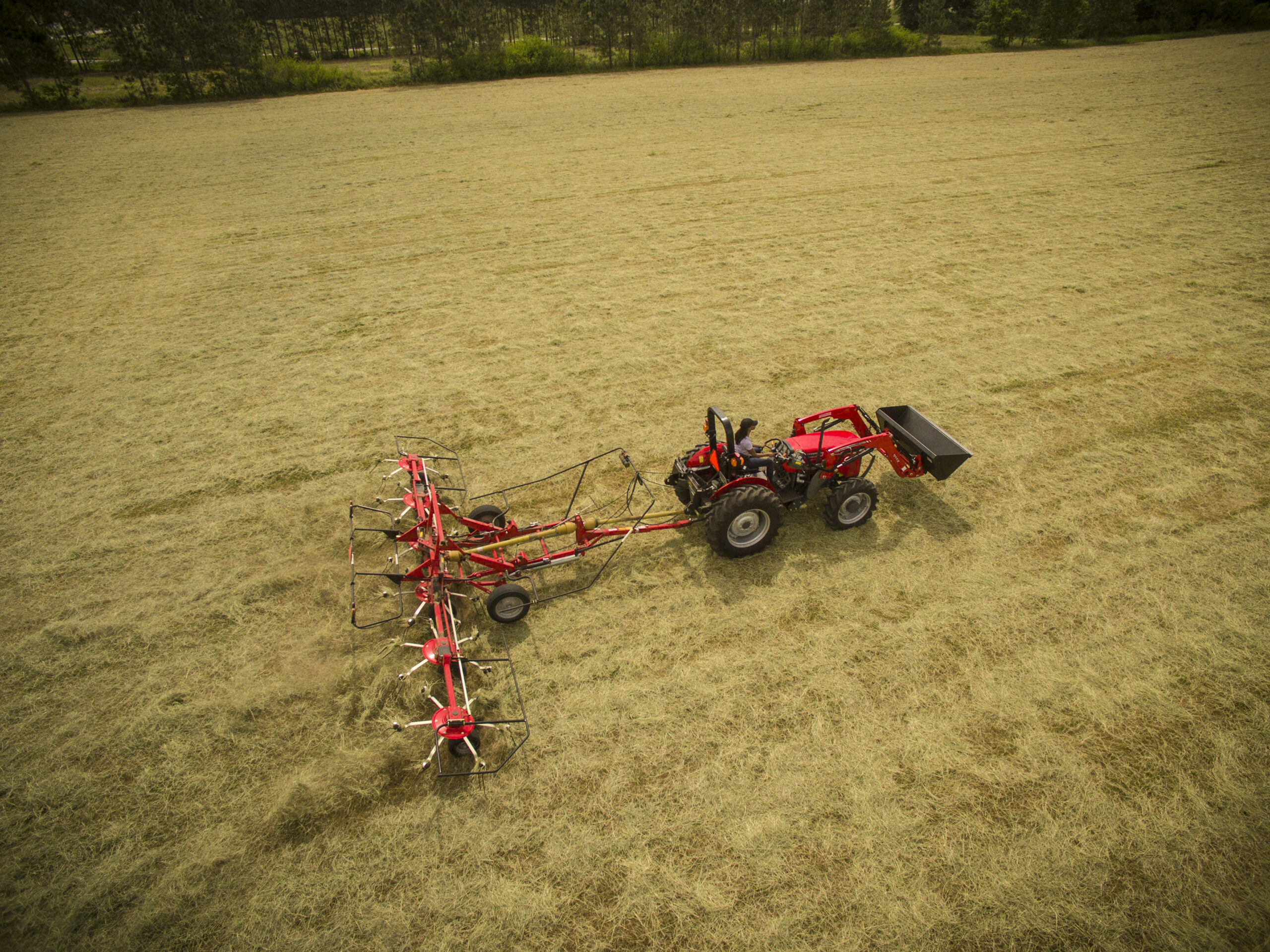 Operator mowing field with a Massey Ferguson 2600H utility tractor, built for dependable performance in pasture and land management.