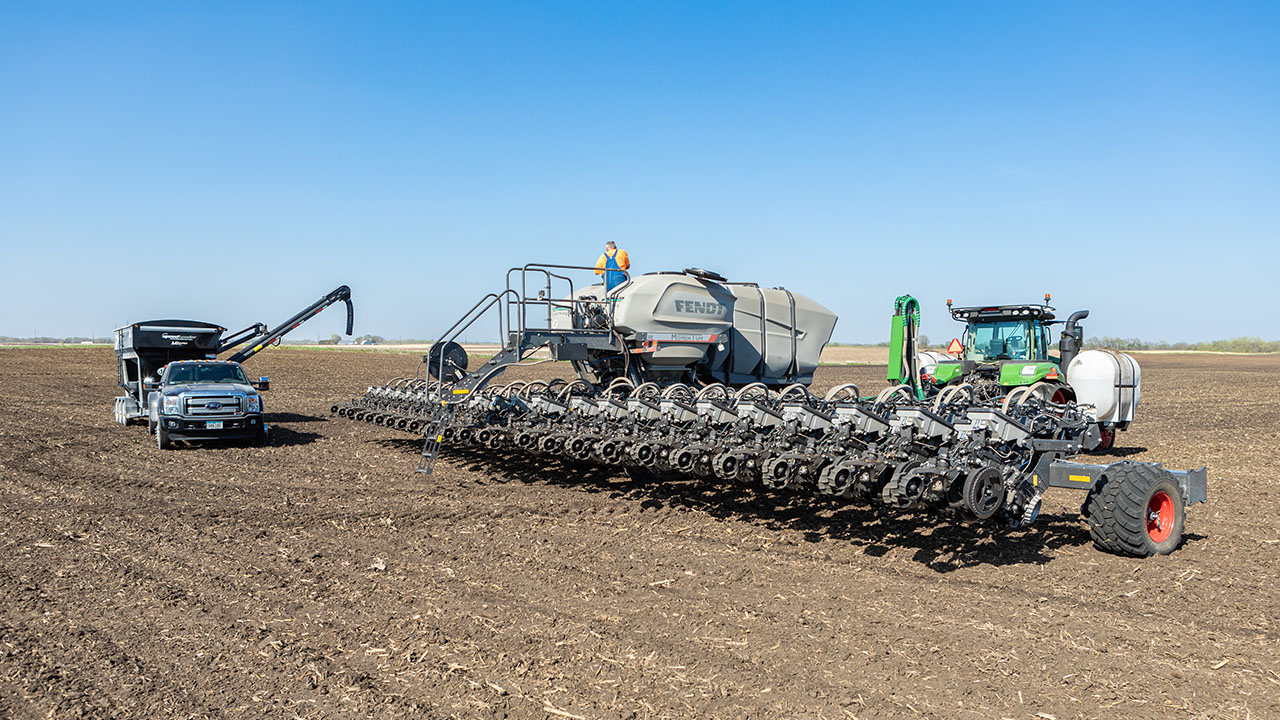 Fendt Momentum planter with Fendt tractor and seed tender operating in open field during spring planting season.