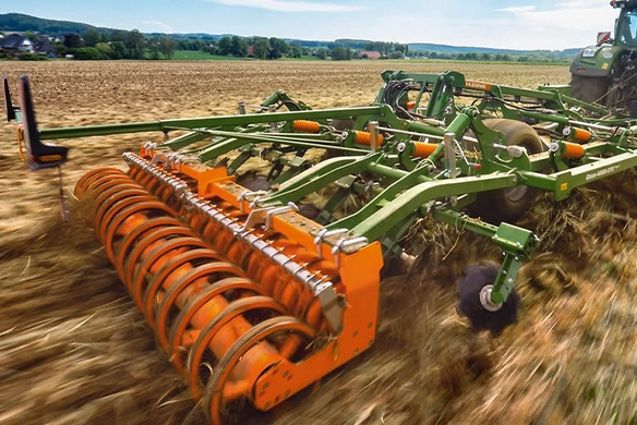 Amazone Ceus cultivator operating in a stubble field, demonstrating powerful soil penetration and residue incorporation with a Fendt tractor.