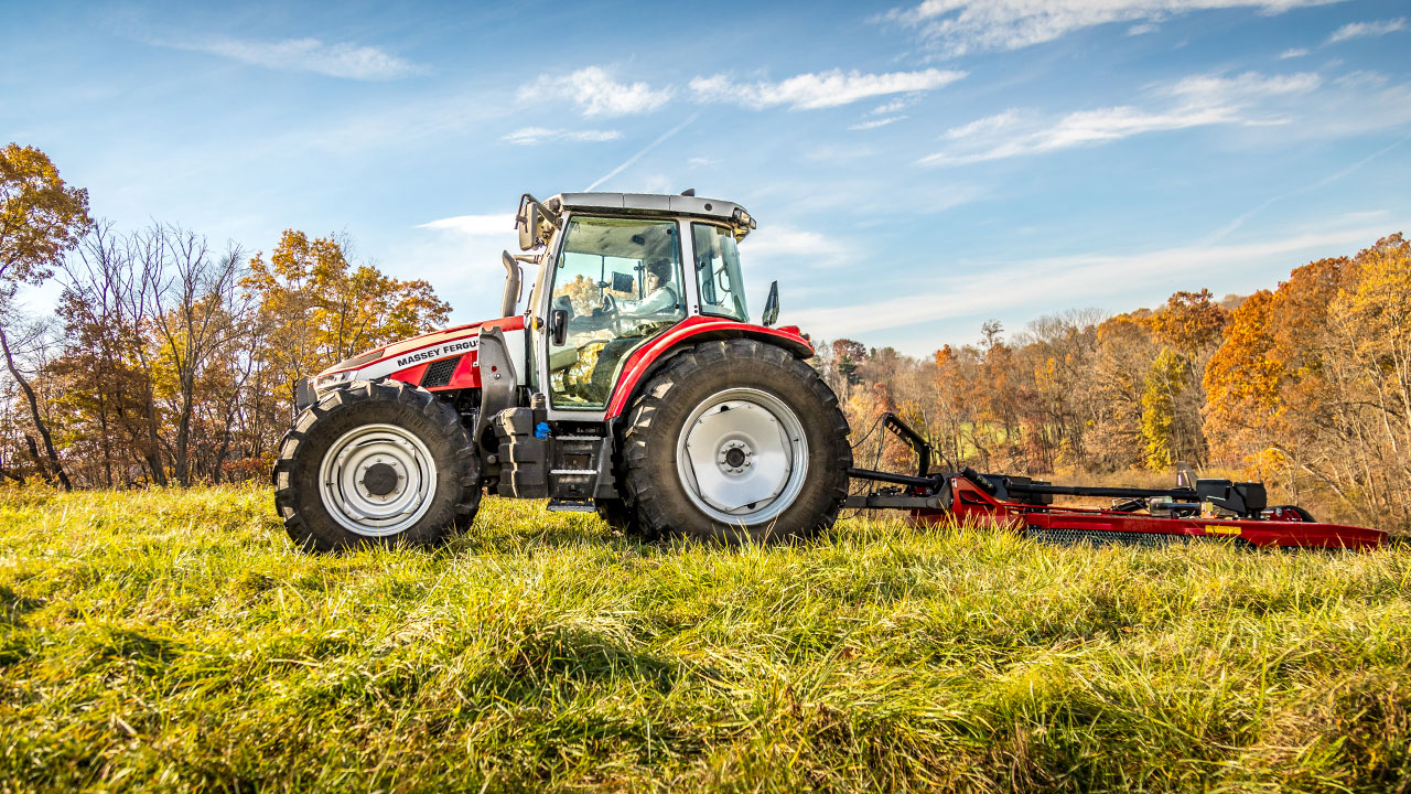Massey Ferguson 5S Series tractor operating a rear mower on a grassy hill during autumn, ideal for hay and pasture management.