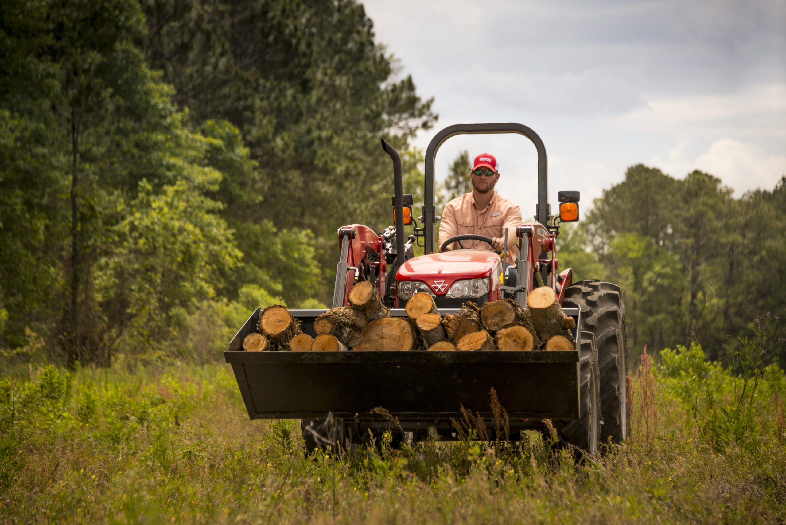 Operator mowing field with a Massey Ferguson 2600H utility tractor, built for dependable performance in pasture and land management.